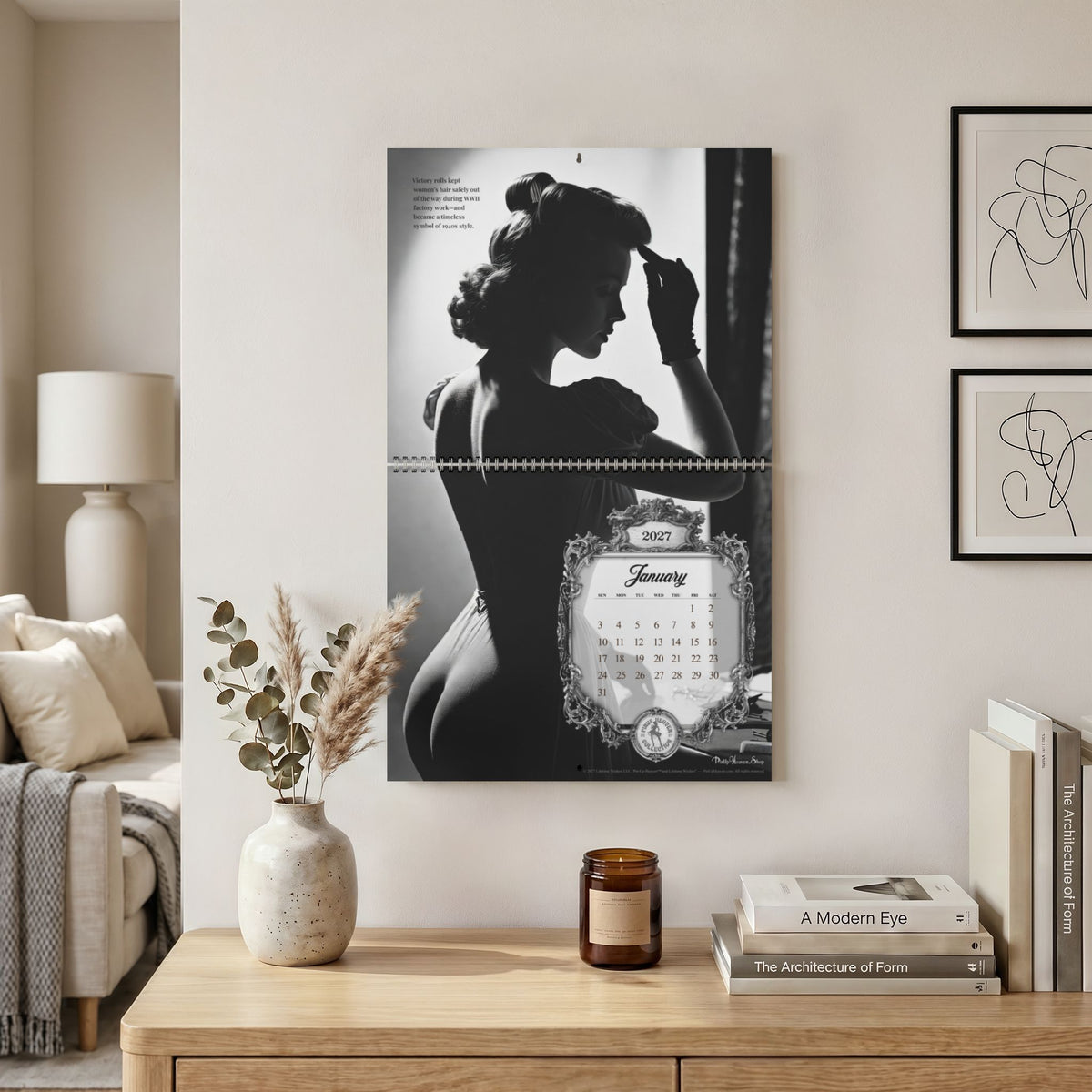 Monochrome Bombshells 2027 Pin-Up Calendar by Pin-Up Heaven — hanging on a wall, January page, 14 x 11.5" size