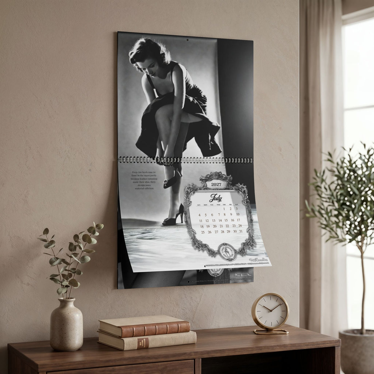 Monochrome Bombshells 2027 Pin-Up Calendar by Pin-Up Heaven — hanging on a wall, July page, 14 x 11.5" size
